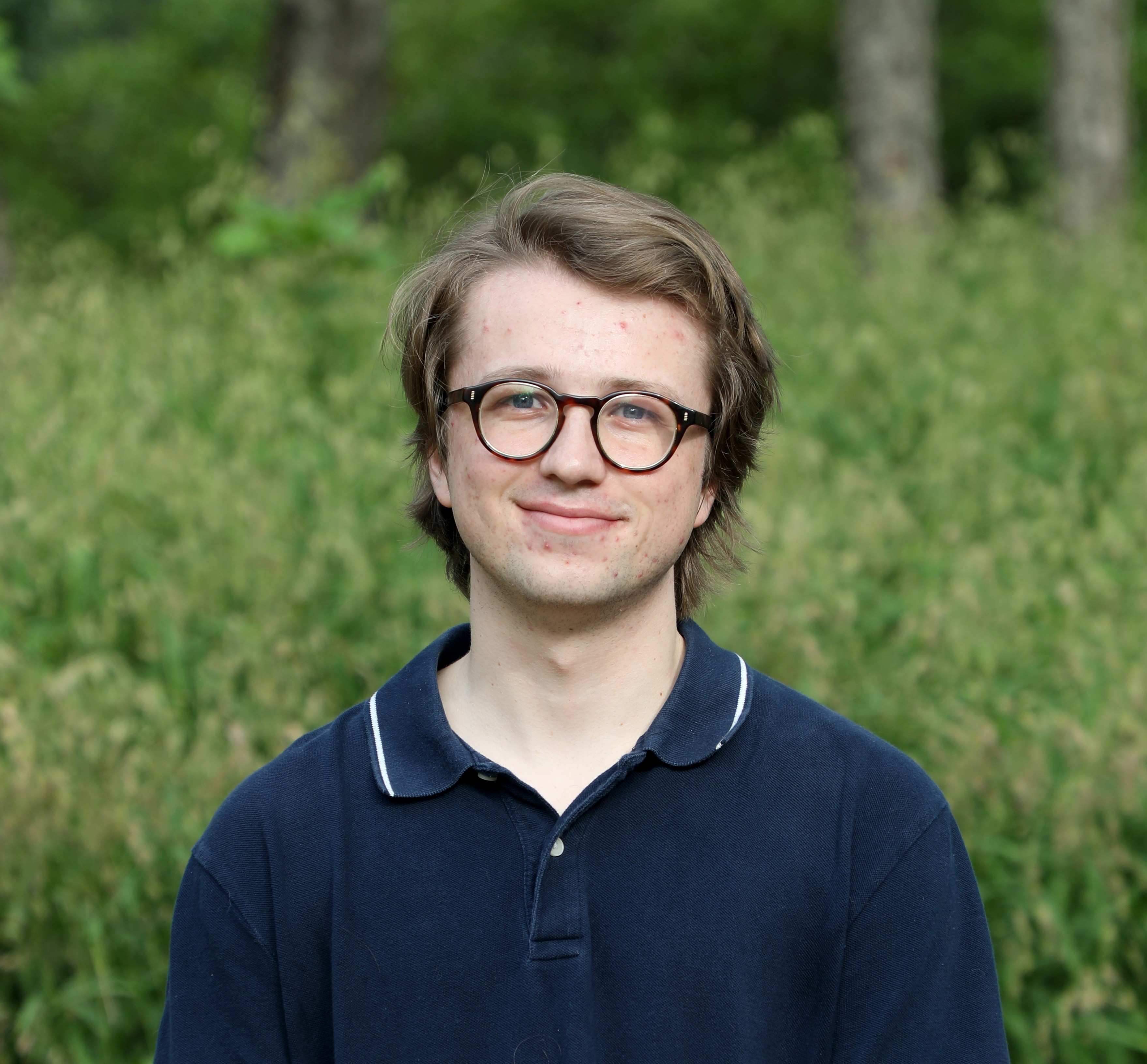 young man with glasses smiling