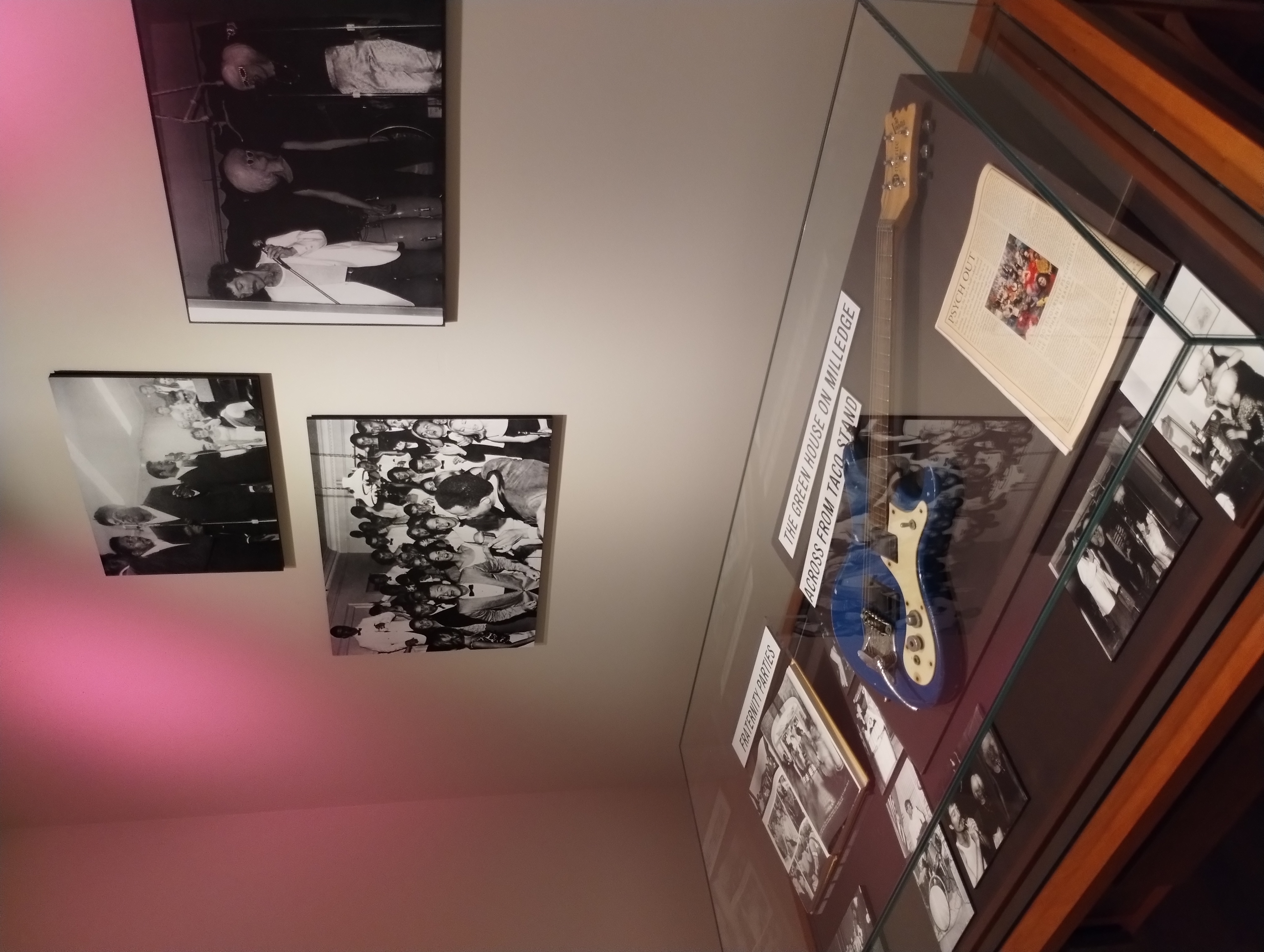 Photos and a guitar on display as party of an exhibit on House Parties in Athens