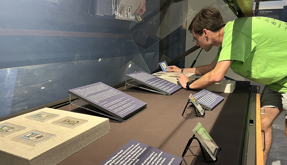 A student takes a close-up look at baseball cards in an exhibit case