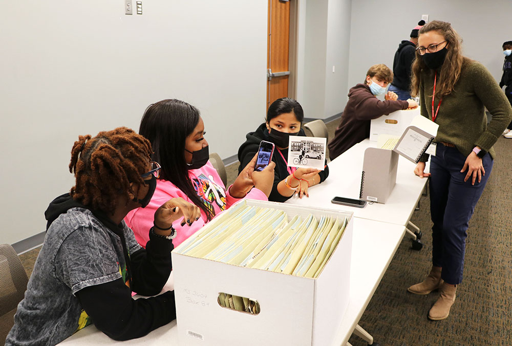 Student takes a photo of an image found in the archives