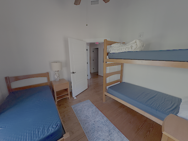 A bedroom with one set of bunk beds and one single bed.