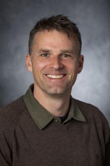 Man wearing collared shirt under pullover sweater