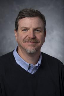 Blue eyed man with mustache and goatee