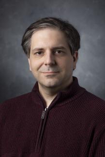 Man wearing a dark red zip-up jacket.