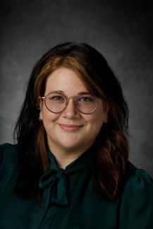 Woman Smiling with glasses and a dark shirt