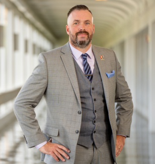 Man in suit with bear and hands on hips