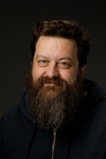 Man with black shirt and beard smiling