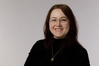 Smiling woman with dark shirt and glasses