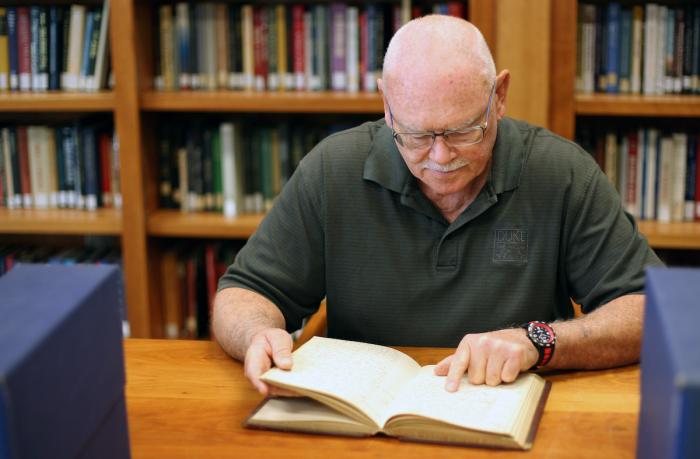Russell Library research volunteer Bill Hugunine explores material for an upcoming exhibit in the Russel reading room. 