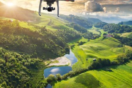 drone flying and collecting environmental data over a green lush landscape