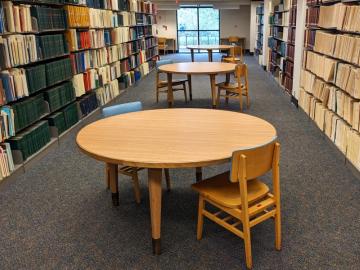 Round tables between book shelves